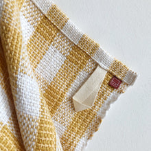 Load image into Gallery viewer, a close-up of a white and yellow teatowel showing the tidy hem, cotton loop and small branded tag
