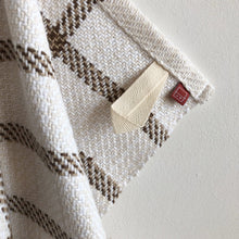Load image into Gallery viewer, a close-up of a white and brown teatowel showing the tidy hem, cotton loop and small branded tag

