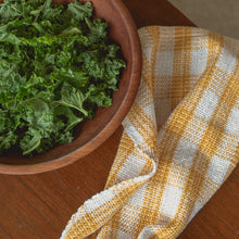 Load image into Gallery viewer, a white and yellow teatowel sits on a dark wood table next to a wooden bowl filled with green kale
